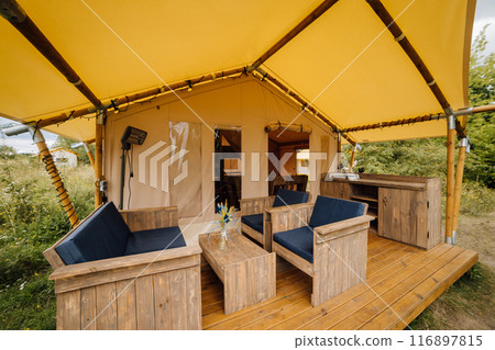 Interior of cozy open glamping tent. Camping tent for outdoor summer holiday and vacation 116897815
