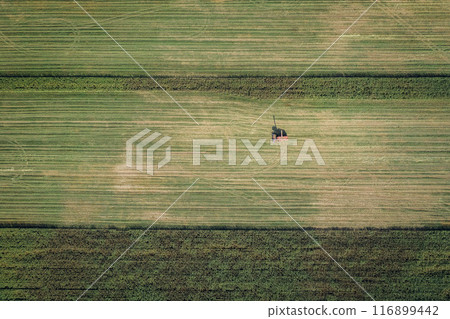 Observe an Aerial Perspective of a Solitary Farmer Tending to a Expansive Verdant Farmland Observe an Aerial Perspective of a Solitary Farmer Tending to a Expansive Verdant Farmland 116899442