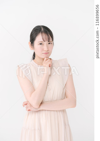 A young woman wearing a dress posing in a thinking position 116899656