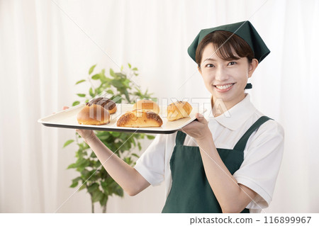 Female bakery staff holding freshly baked bread 116899967