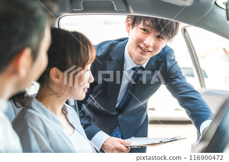 A young Asian male salesman serving customers who came to buy, assess and purchase a car 116900472