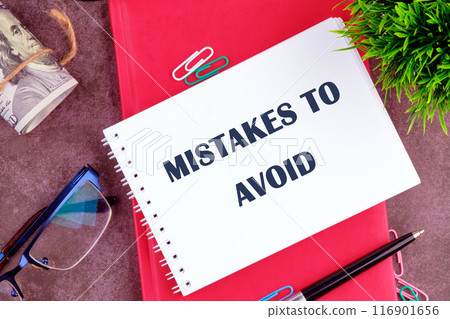 MISTAKES TO AVOID, text in a notebook on a blank sheet in a composition with glasses, dollars, a pen and an ornamental plant MISTAKES TO AVOID, text in a notebook on a blank sheet in a composition with glasses, dollars, a pen and an ornamental plant 116901656