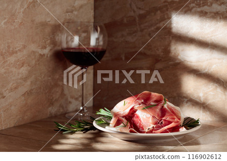 Prosciutto or Spanish jamon with rosemary and red wine. Prosciutto or Spanish jamon with rosemary and red wine. 116902612