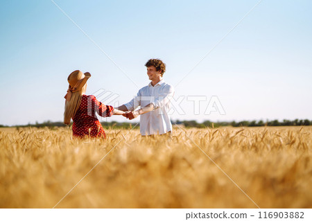 Loving couple having fun and enjoying relaxation in a wheat field. Loving couple having fun and enjoying relaxation in a wheat field. 116903882