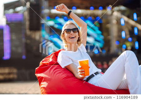 Happy woman drinking beer and having fun at music festival. Beach party, summer holiday concept. 116904189