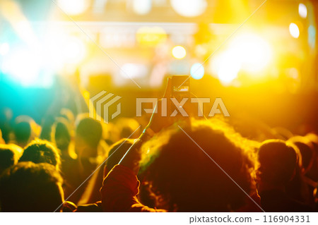 Fans enjoying rock concert with light show and clapping hands. Fans enjoying rock concert with light show and clapping hands. 116904331