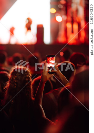 Fans enjoying rock concert with light show and clapping hands. Fans enjoying rock concert with light show and clapping hands. 116904339