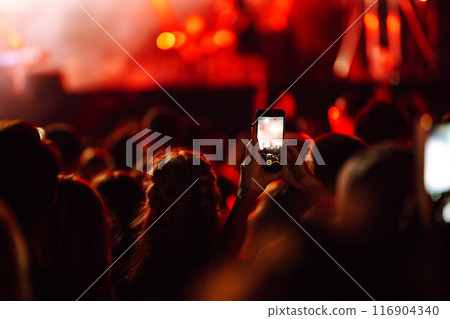 Fans enjoying rock concert with light show and clapping hands. Fans enjoying rock concert with light show and clapping hands. 116904340