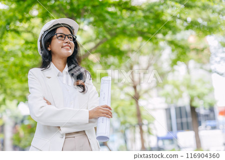 Portrait smart young engineer women standing with floorplan at green park nature. Environmental saving energy project designer. Portrait smart young engineer women standing with floorplan at green park nature. Environmental saving energy project designer. 116904360