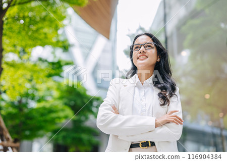 Portrait Indian business women female happy smile. Young Asian success businesswomen happy at green city office park outdoors. Portrait Indian business women female happy smile. Young Asian success businesswomen happy at green city office park outdoors. 116904384