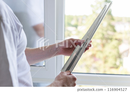 Man holding a roll of tint film for windows Man holding a roll of tint film for windows 116904527
