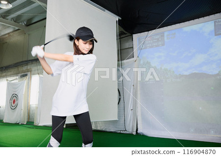 一名女子在室內高爾夫練習場練習 116904870