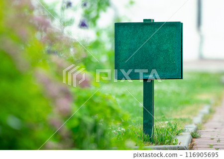 The green information board mockup integrates seamlessly into the verdant garden setting The green information board mockup integrates seamlessly into the verdant garden setting 116905695