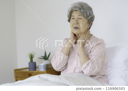 Senior woman holding her throat in bedroom 116906383