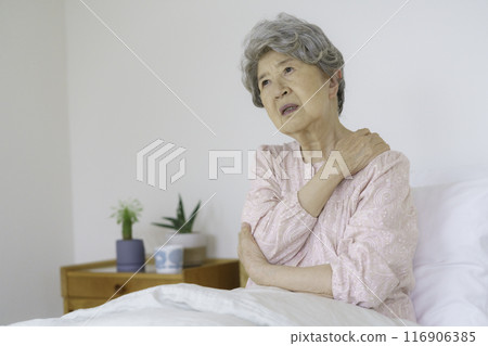 Senior woman holding her shoulders in the bedroom Senior woman holding her shoulders in the bedroom 116906385