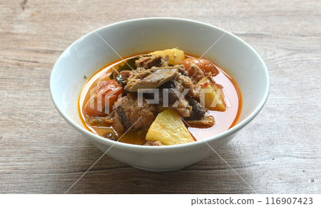 spicy boiled roasted duck meat with pineapple and tomato in coconut milk curry soup on bowl 116907423