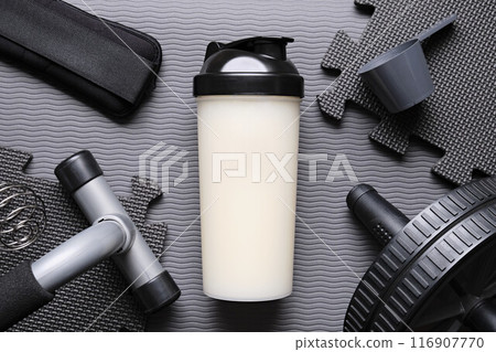 Protein and exercise equipment on a yoga mat 116907770