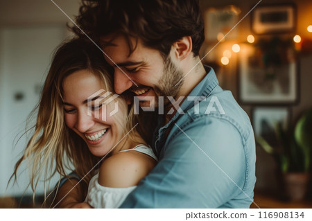 Smiling couple dancing and hugging in living room 116908134