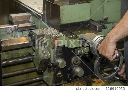 The machine operator working with lathe machine. 116910953