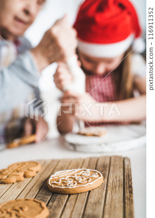 Closeup of baked cookies decorating with cream on background at Christmas Closeup of baked cookies decorating with cream on background at Christmas 116911352