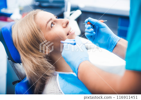 Dentist treating blond smiling girl 116911451