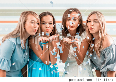 Smiling girls shoot confetti on striped background 116911525