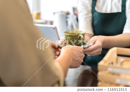 櫃檯上的店員正在遞咖啡 櫃檯上的店員正在遞咖啡 116911913