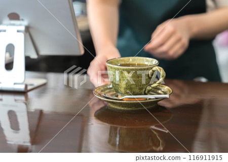 A waiter handing out coffee at the counter A waiter handing out coffee at the counter 116911915