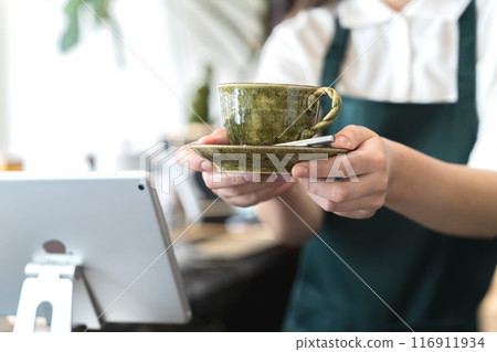 櫃檯上的店員正在遞咖啡 櫃檯上的店員正在遞咖啡 116911934