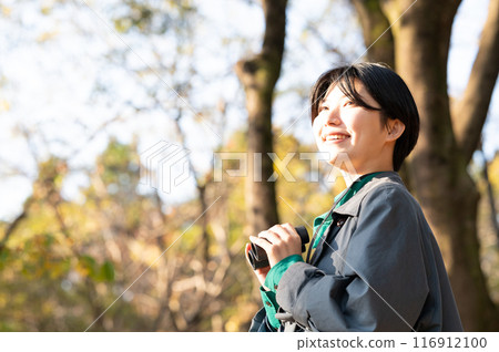 Young lady with bird watching 116912100