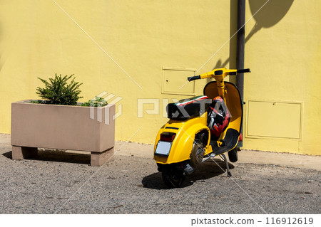 Yellow Scooter and Plant Pot on City Street 116912619