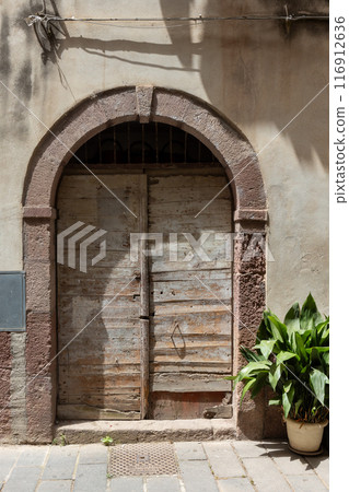 Old Wooden Door with Archway in Historic City 116912636