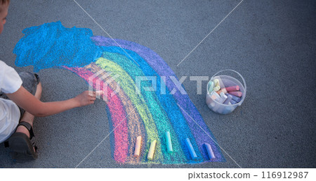 Children draw a rainbow on the asphalt with colored chalk. Sidewalk. Children draw a rainbow on the asphalt with colored chalk. Sidewalk. 116912987