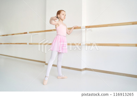 Young ballet girl at studio lesson. Training performance. Stretching exercise Young ballet girl at studio lesson. Training performance. Stretching exercise 116913265