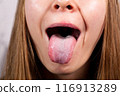 Female tongue. Close-up Of A Woman's Face Showing Her Clean Tongue 116913289
