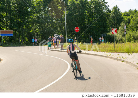 Female cyclist in sport clothing, protective helmet and glasses Female cyclist in sport clothing, protective helmet and glasses 116913359