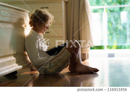 Child with books doing homework after school. 116913956