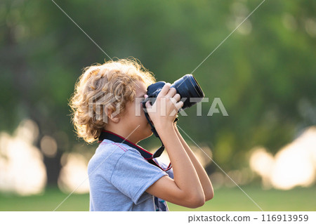 Child learning to take photos. Kid photographer. Child learning to take photos. Kid photographer. 116913959