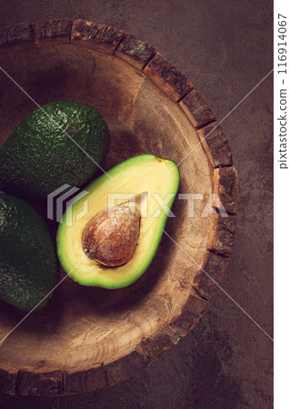 fresh, sliced avocado, in a wooden plate, top view, food background, concept, food styling fresh, sliced avocado, in a wooden plate, top view, food background, concept, food styling 116914067