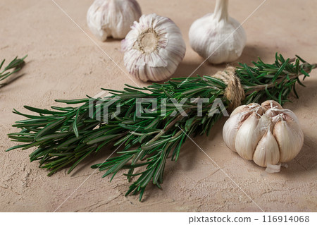 fresh bunch of rosemary with garlic, on a beige background, food concept, 116914068
