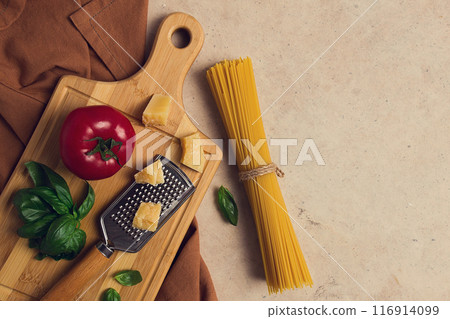 Raw pasta with ingredients, on a beige background, top view, rustic style, selective focus, no people. 116914099