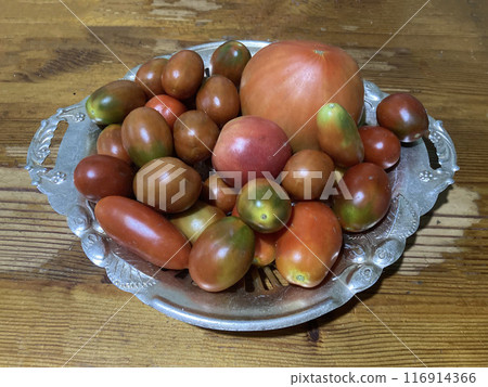 Fresh summer tomatoes lie on a plate Fresh summer tomatoes lie on a plate 116914366