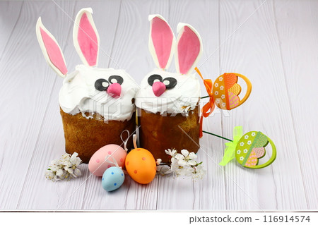 Stand with Easter cake, painted eggs and bunny on wooden background Stand with Easter cake, painted eggs and bunny on wooden background 116914574