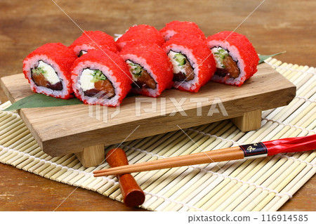 Sushi delivery. Set of rolls in a disposable box on a black background. Top view 116914585
