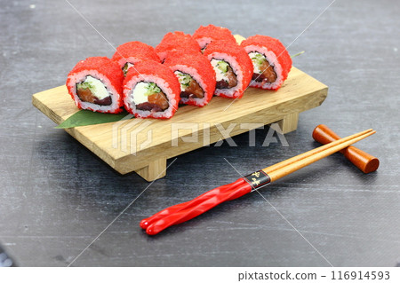 Sushi delivery. Set of rolls in a disposable box on a black background. Top view 116914593