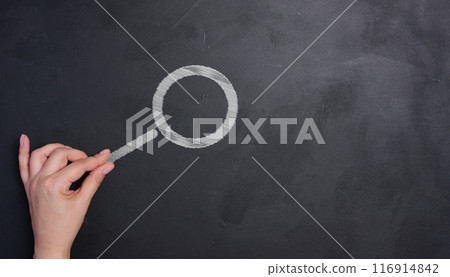 A woman's hand and a magnifying glass drawn with white chalk on a black chalk board 116914842