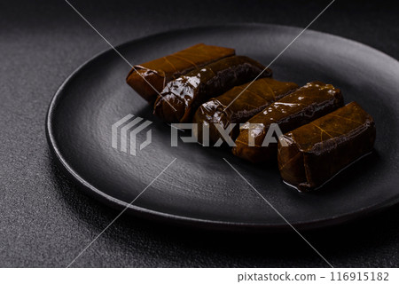 Delicious dolma in the form of rice and meat wrapped in grape leaves Delicious dolma in the form of rice and meat wrapped in grape leaves 116915182