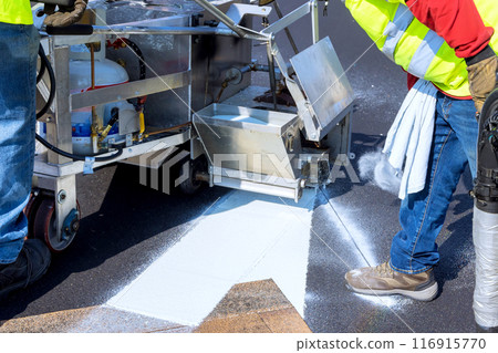 Airbrush machines are used to apply road markings after asphalt has been laid on road 116915770