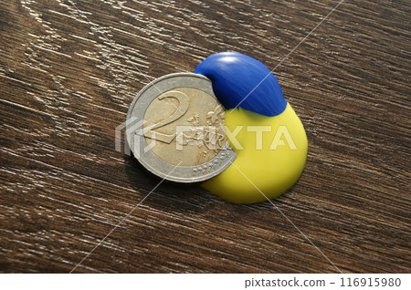 2 Euro coin on a dark wooden table. 2 Euro coin on a dark wooden table. 116915980