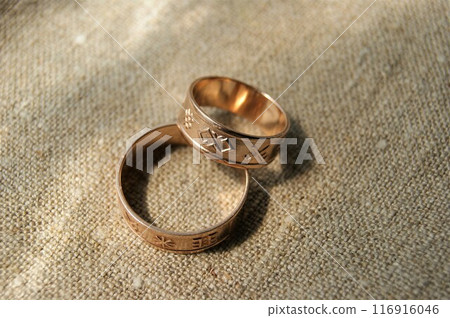 Gold wedding rings with ancient symbols. Gold jewelry. Latvian ancient symbols. Gold wedding rings with ancient symbols. Gold jewelry. Latvian ancient symbols. 116916046